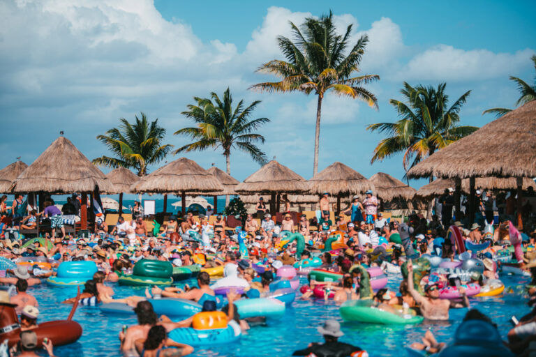 Pool party scene with guests floating on inflatables