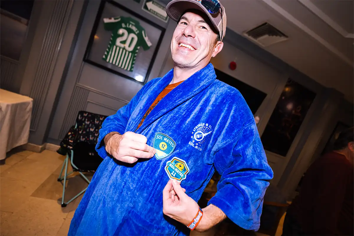Guest wearing blue loyalty program robes posing with loyalty patches