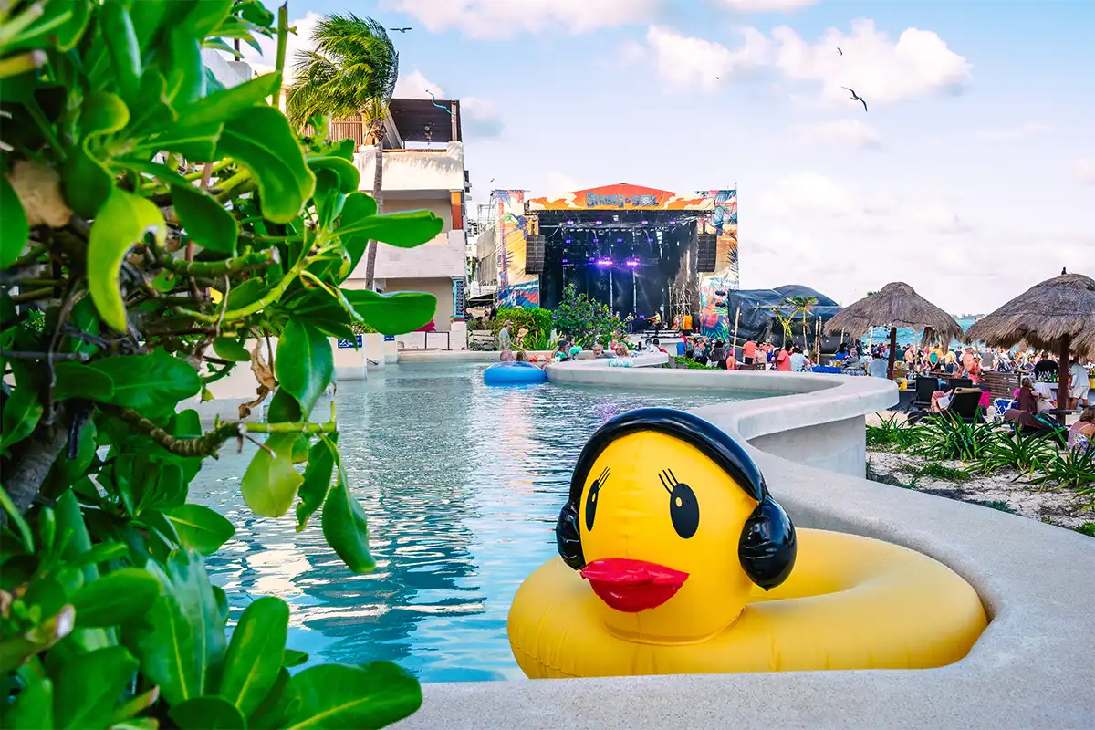 Oceanfront Suite swim up pool with yellow duck float in foreground and beach stage in the distance