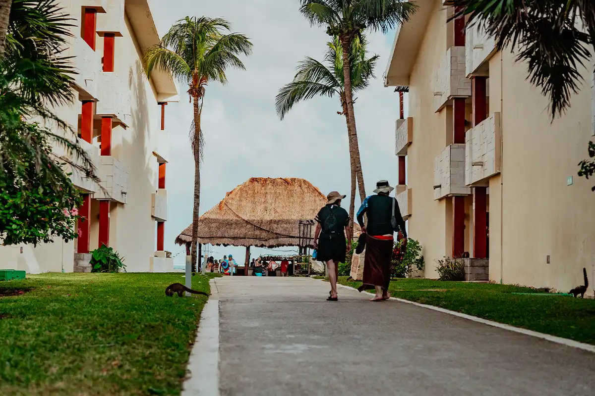 Guests walking along pathway toward beachside bar area.