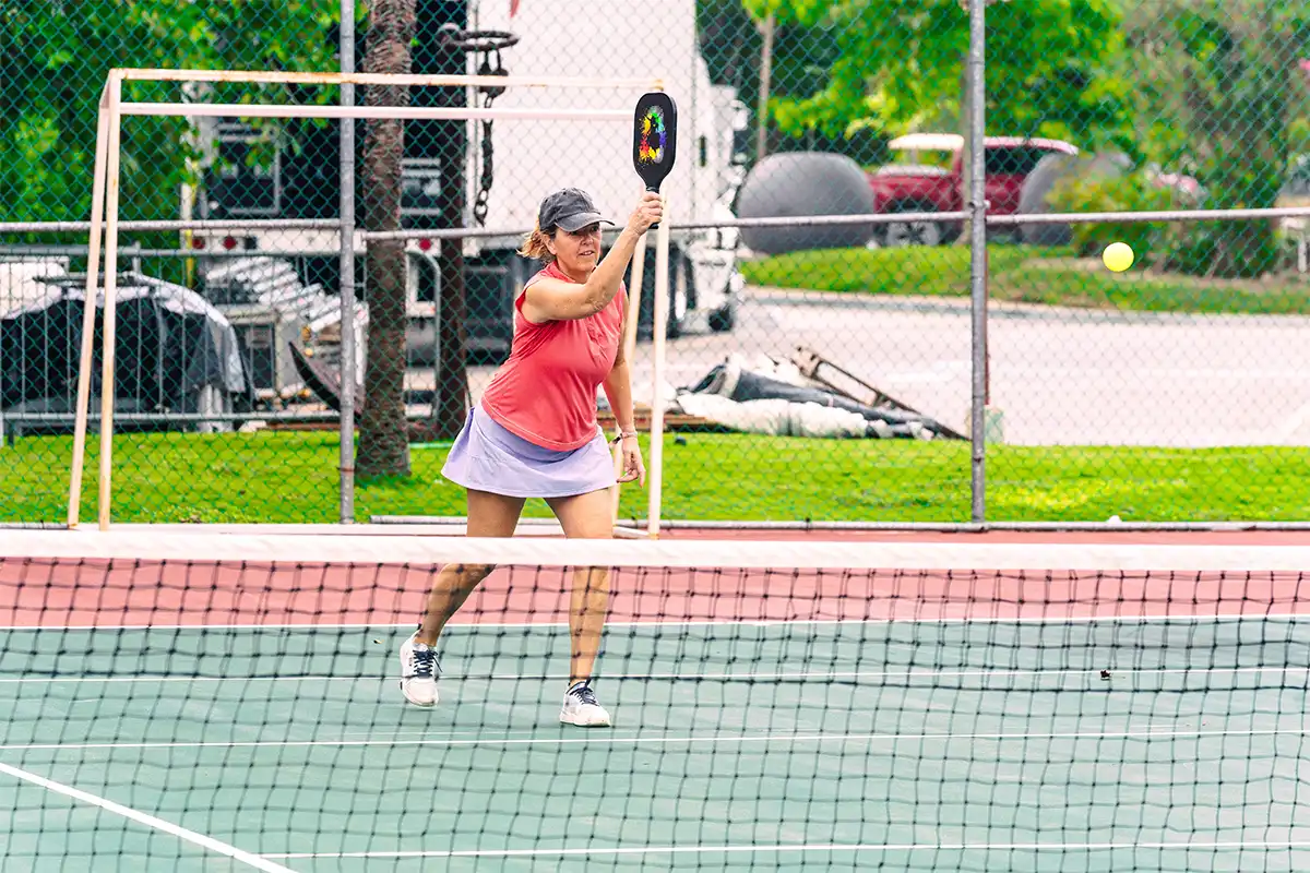 Guest playing pickleball on courts present on the resort property.