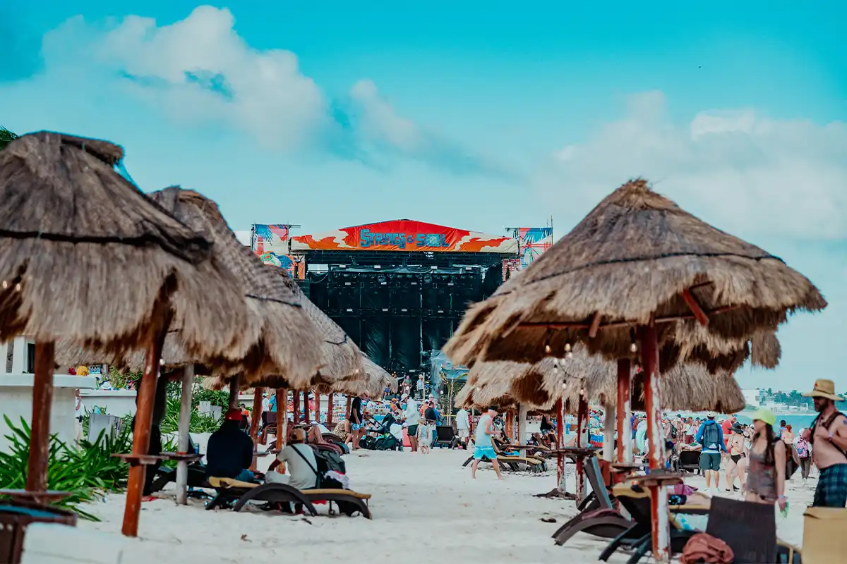 Beachfront lounge area with palapas and Beach Stage in the background.