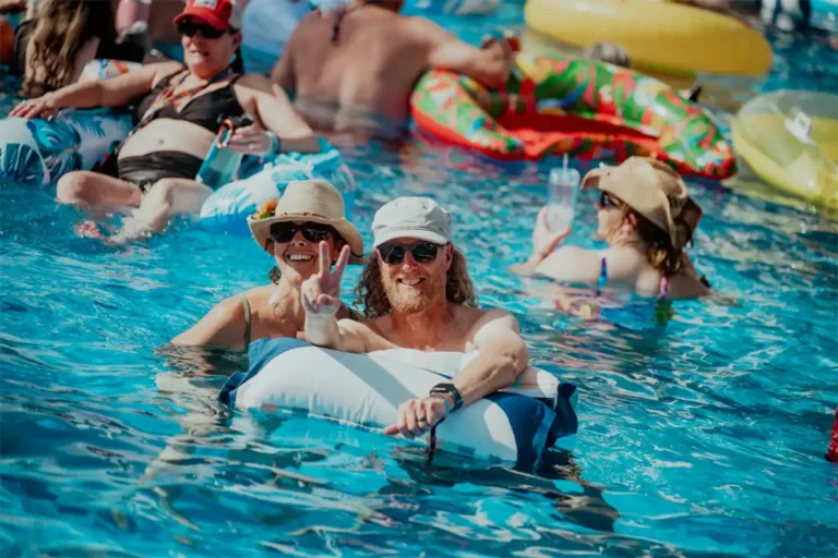 Guests posing and smiling in the pool.