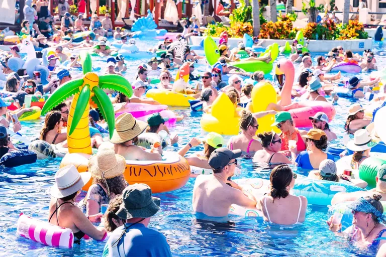 A crowd of guests on pool inflatables watching a daytime concert.