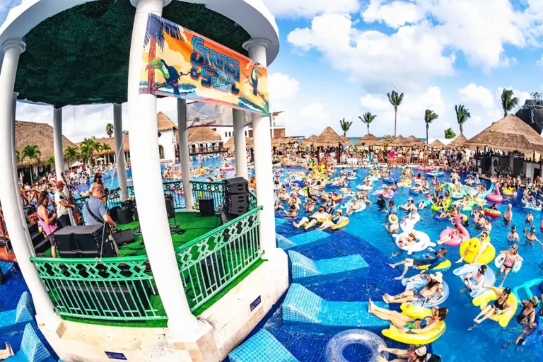 A poolside gazebo stage concert, guests surrounding the stage on pool floats.