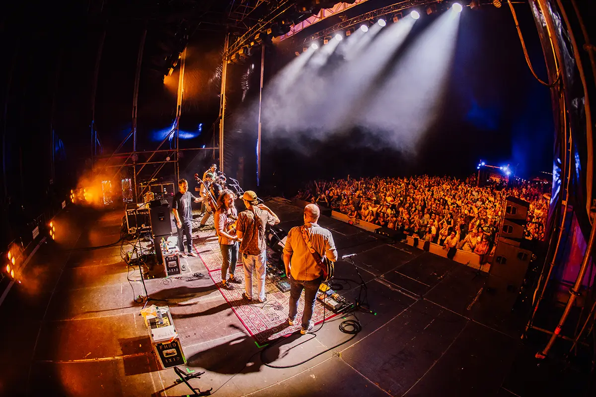 View from Beach Stage of band performing in front of large crowd at night.