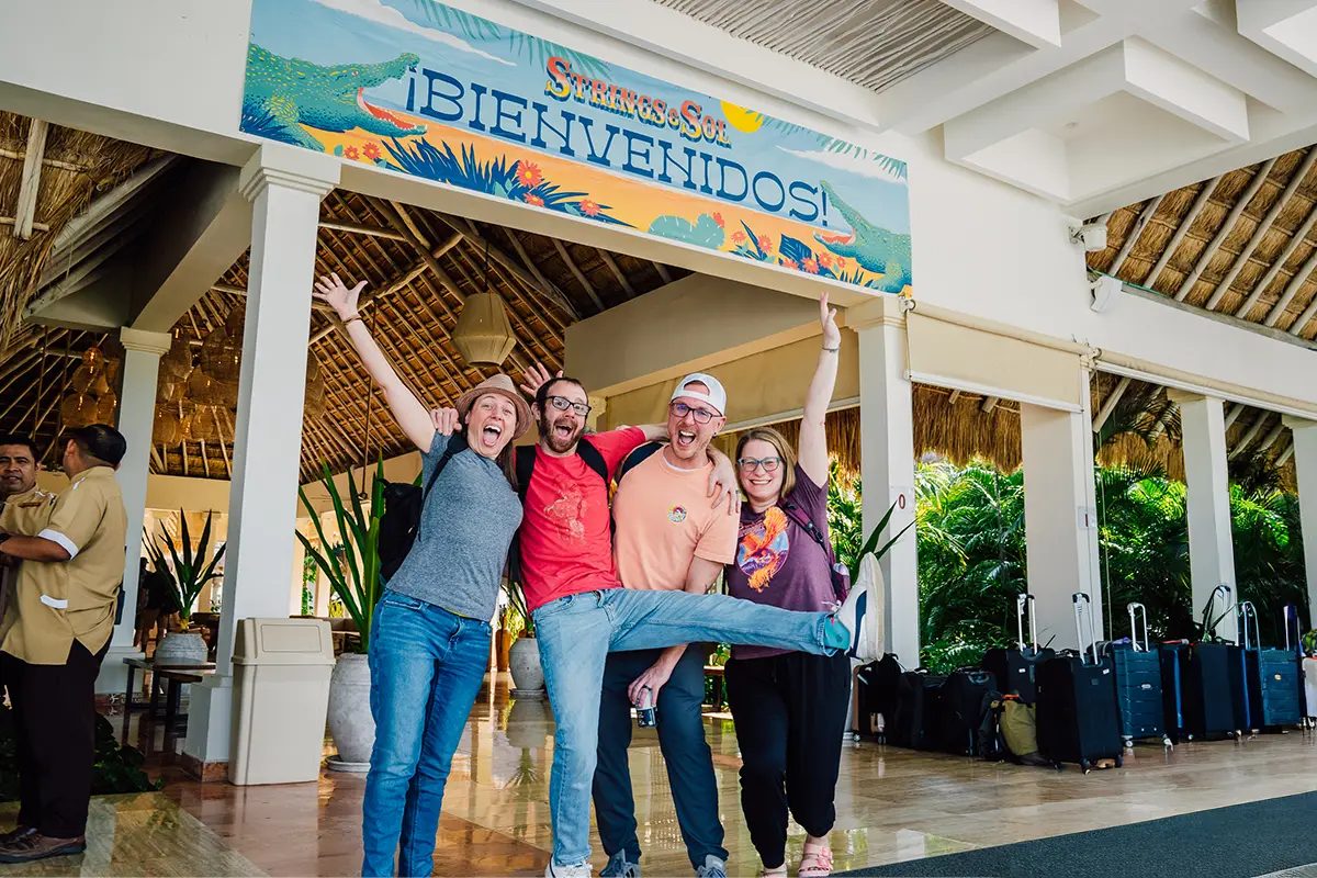 Guests posing in front of a welcome banner in the resort lobby.